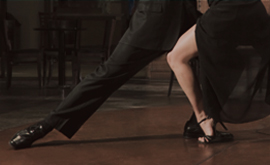 Füße und Beine von Mann und Frau im Tango typischen Ausfallschritt